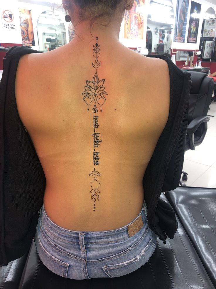 tattoo chữ phạn ở sau lưng cho nữ Hình xăm hoa sen dọc sống lưng phong cách blackwork, chi tiết, ảnh HD.