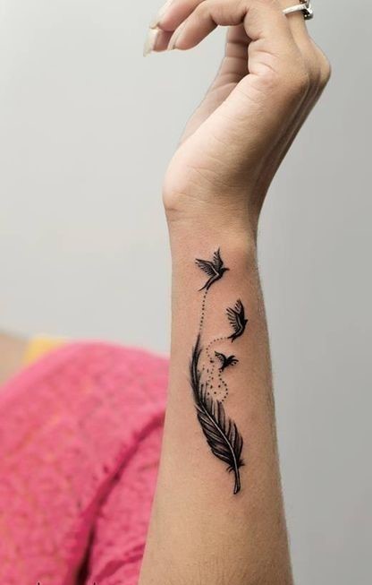 Hình xăm dọc cổ tay đàn chim bay sống động Hình xăm lông vũ và chim trên cổ tay, phong cách blackwork, chi tiết rõ nét, ảnh HD.