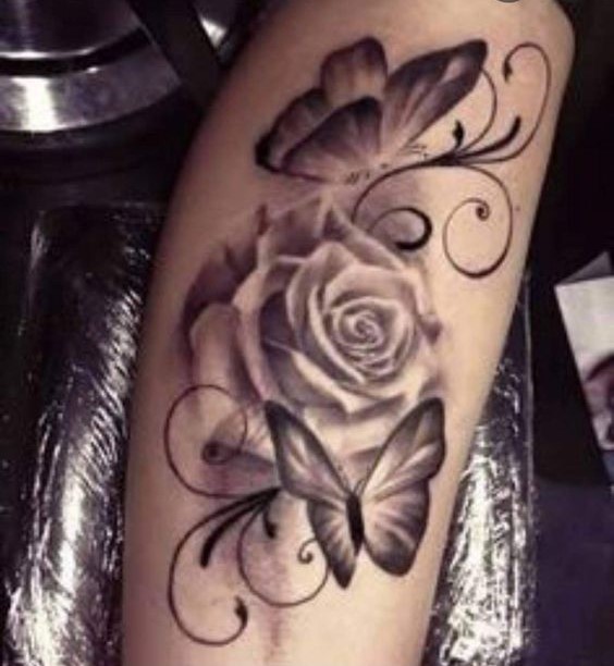 Hình xăm hoa hồng và bướm phong cách blackwork, trên cánh tay, chi tiết rõ nét.