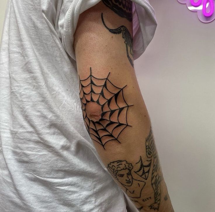 Hình xăm mạng nhện trên khuỷu tay, phong cách blackwork, chi tiết rõ nét, ảnh HD.