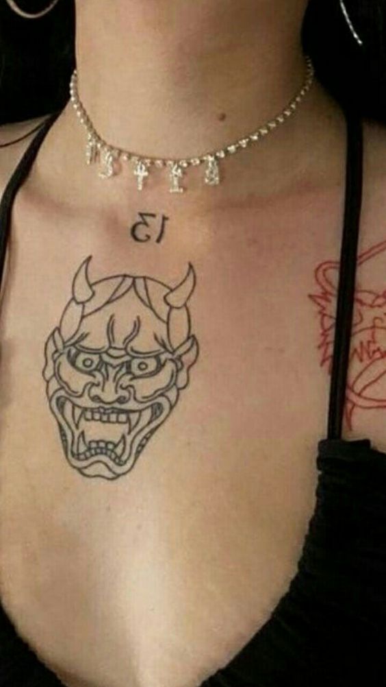Hình xăm mặt quỷ trên ngực, phong cách blackwork, chi tiết rõ nét, ảnh chất lượng HD.