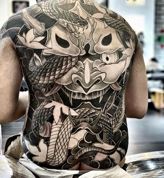Hình xăm mặt quỷ và rắn trên lưng, phong cách blackwork, chi tiết cao, độ phân giải HD.