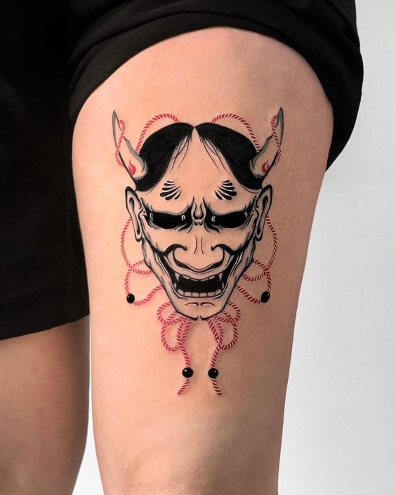 Hình xăm mặt nạ Oni blackwork trên đùi, chi tiết sắc nét, phong cách Nhật Bản, ảnh HD.