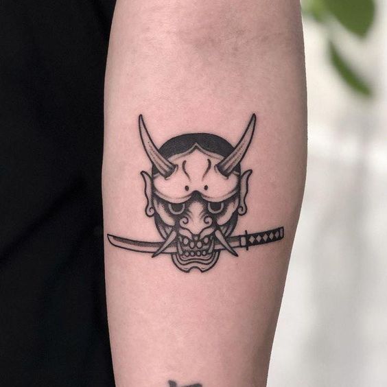 Hình xăm mặt quỷ Nhật Bản trên cánh tay, phong cách blackwork, chi tiết rõ nét, HD.