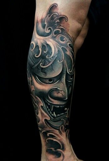 Hình xăm mặt quỷ phong cách blackwork trên bắp chân, chi tiết sắc nét, ảnh HD.