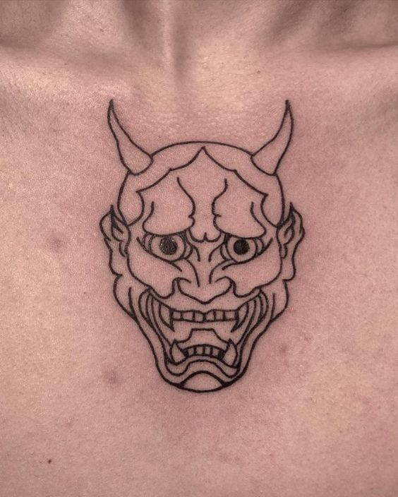 Hình xăm mặt nạ quỷ trên ngực, phong cách blackwork, chi tiết rõ nét, ảnh HD.