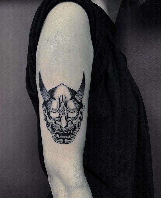 Hình xăm mặt nạ Nhật Bản trên cánh tay, phong cách blackwork, chi tiết sắc nét, ảnh HD.