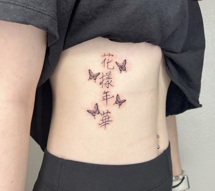Hình xăm chữ và bướm trên eo, phong cách blackwork, chi tiết rõ nét, ảnh HD.