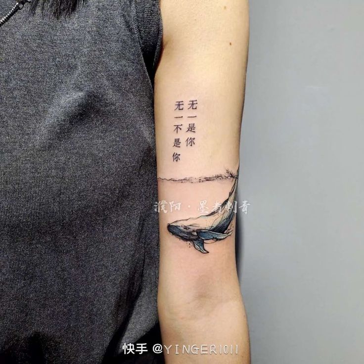 Hình xăm cá voi và chữ, vị trí bắp tay, phong cách blackwork, độ phân giải HD.