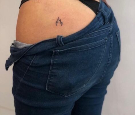 Hình xăm ngọn lửa mini ở hông, phong cách blackwork, chi tiết đơn giản, ảnh chất lượng HD.
