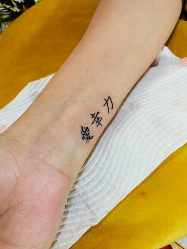 Hình xăm chữ Nhật mini trên cổ tay, phong cách blackwork, ảnh HD chi tiết.