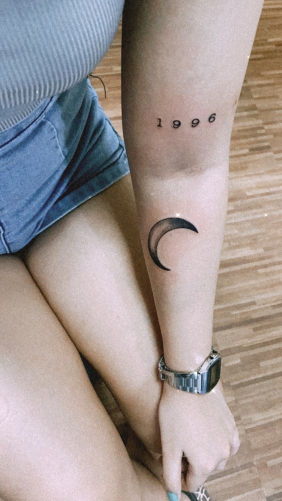 Hình xăm chữ số và mặt trăng trên cánh tay, phong cách blackwork, ảnh chất lượng HD.