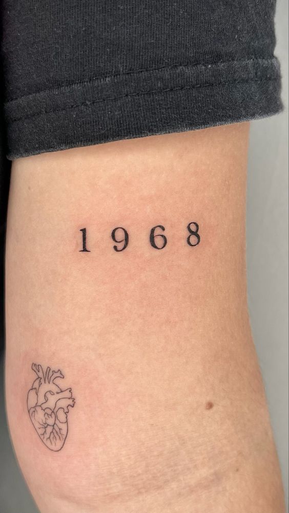 Hình xăm số "1968" và hình trái tim tối giản trên tay, phong cách blackwork, độ phân giải HD.