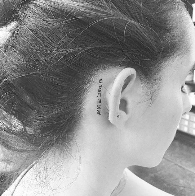 Hình xăm tọa độ nhỏ sau tai, phong cách blackwork, chi tiết rõ nét, ảnh HD.