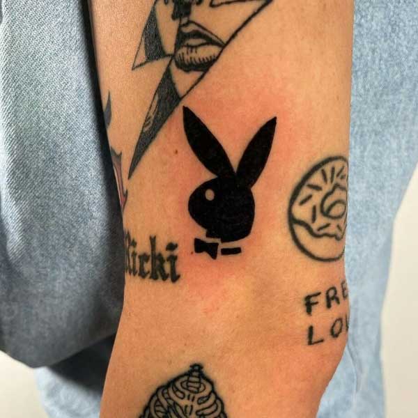 Hình xăm logo thỏ trên cánh tay, phong cách blackwork, chi tiết rõ nét, độ phân giải HD.
