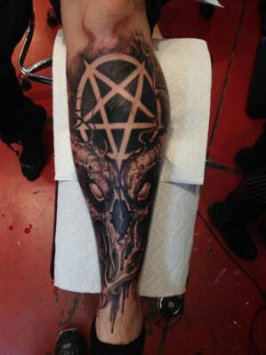 Hình xăm đầu lâu và pentagram ở bắp chân, phong cách blackwork, chi tiết cao, độ phân giải HD.