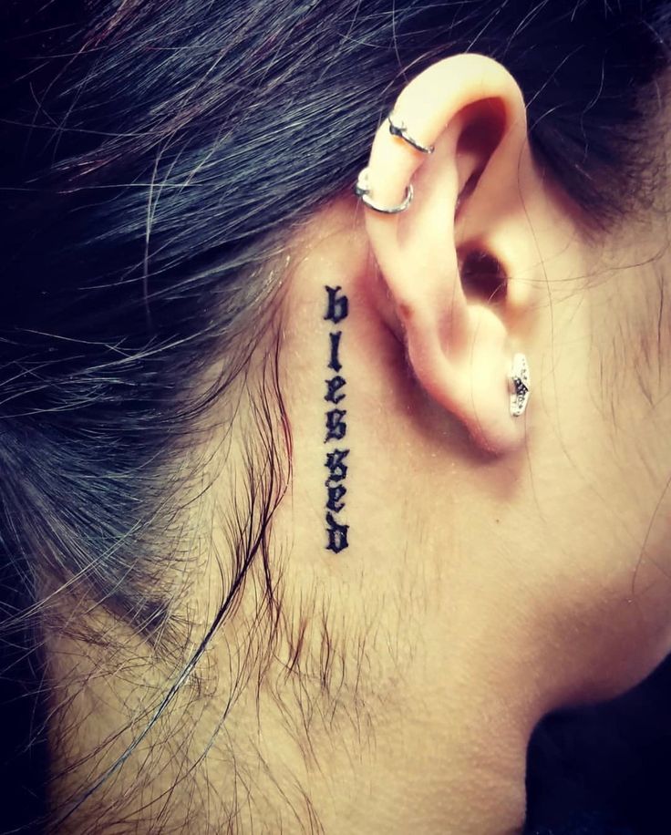 Hình xăm chữ "blessed" phong cách blackwork sau tai, chi tiết rõ nét, ảnh HD.