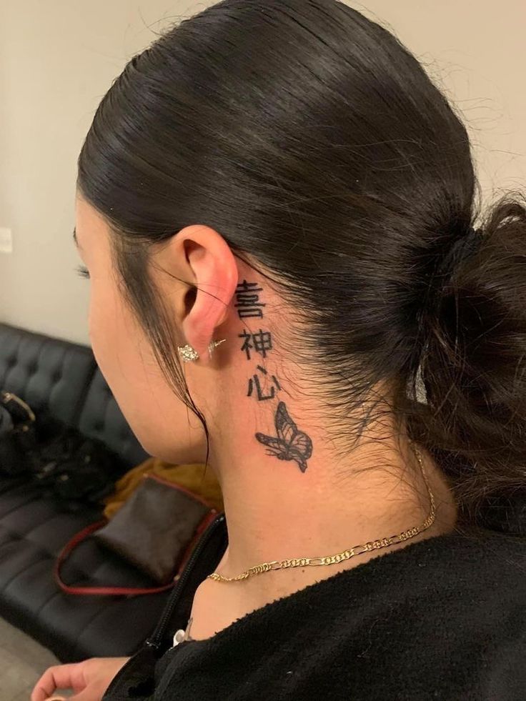 Hình xăm chữ và bướm phong cách blackwork sau tai, chi tiết rõ nét, ảnh HD.