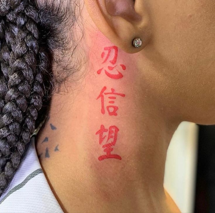 Hình xăm chữ đỏ sau tai, phong cách tối giản, độ phân giải cao, chi tiết rõ nét.