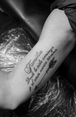 Hình xăm chữ và mũi tên trên cánh tay, phong cách blackwork, ảnh độ phân giải HD, chi tiết rõ nét.
