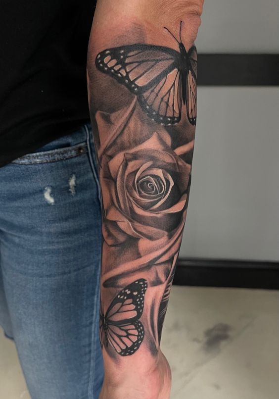 Hình xăm hoa hồng và bướm trên cánh tay, phong cách blackwork chi tiết, ảnh HD.