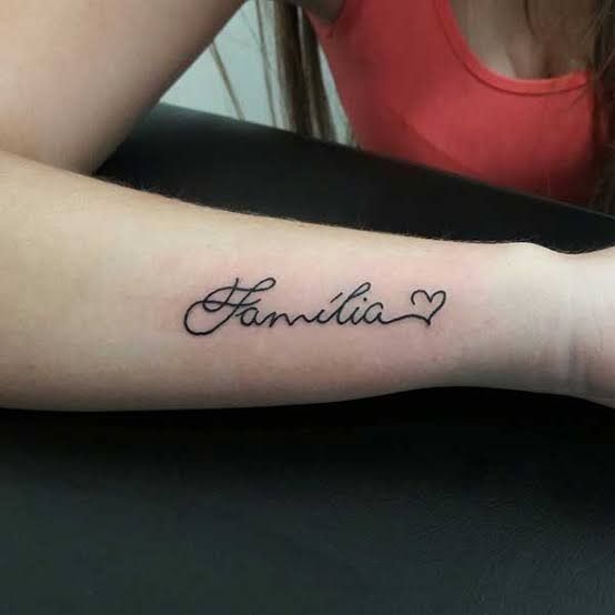 thiết kế xăm chữ gia đình mini ở tay Hình xăm chữ "Família" và trái tim trên cánh tay, phong cách chữ viết tay, ảnh HD.