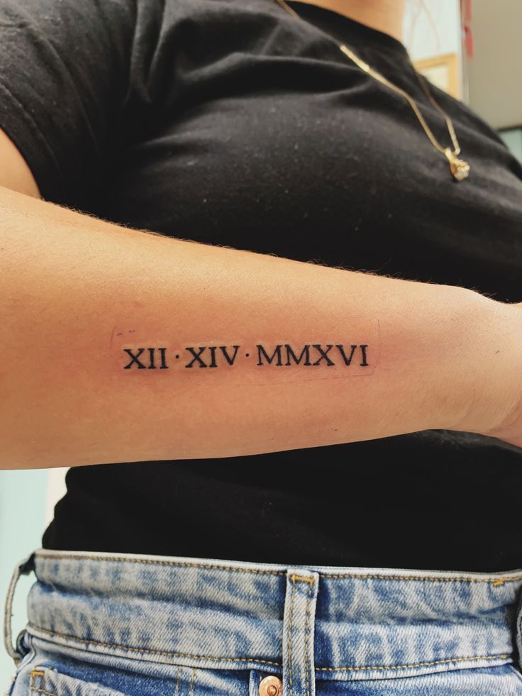 Tinh tế với hình xăm chữ số La Mã trên cẳng tay Hình xăm chữ số La Mã trên cánh tay, phong cách blackwork, chi tiết rõ nét, độ phân giải HD.