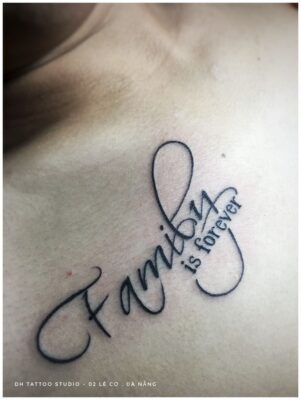 Hình xăm chữ "Family is forever" trên ngực, phong cách chữ viết tay, ảnh HD chi tiết.
