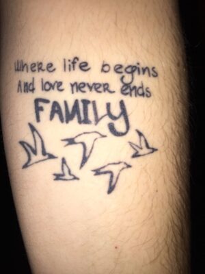 Hình xăm chữ "Family" và chim trên cánh tay, phong cách blackwork, độ phân giải HD.