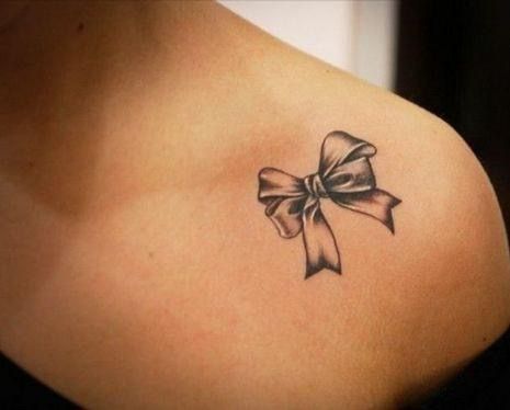 Vị trí xăm nơ quyến rũ Hình xăm nơ nhỏ trên vai, phong cách blackwork, chi tiết sắc nét, độ phân giải HD.
