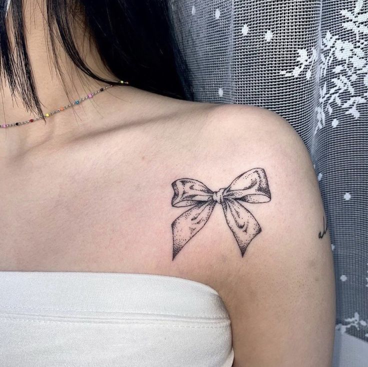 Vị trí xăm nơ ấn tượng Hình xăm nơ trên vai, phong cách blackwork, chi tiết tinh tế, độ phân giải HD.