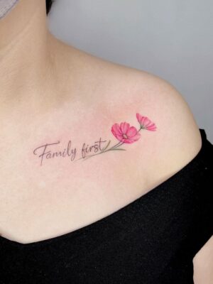 Hình xăm hoa mini trên vai, phong cách màu nước, chữ "Family first", ảnh HD rõ nét.
