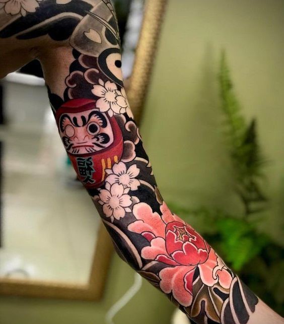 Hình xăm đầy cánh tay mẫu daruma kết hợp hoa anh đào và hoa mẫu đơn độc đáo Hình xăm tay phong cách Nhật Bản với hoa anh đào, Daruma, chi tiết cao, full HD.