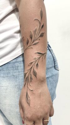 Hình xăm nhánh lá trên cánh tay, phong cách blackwork tinh tế, ảnh HD sắc nét.