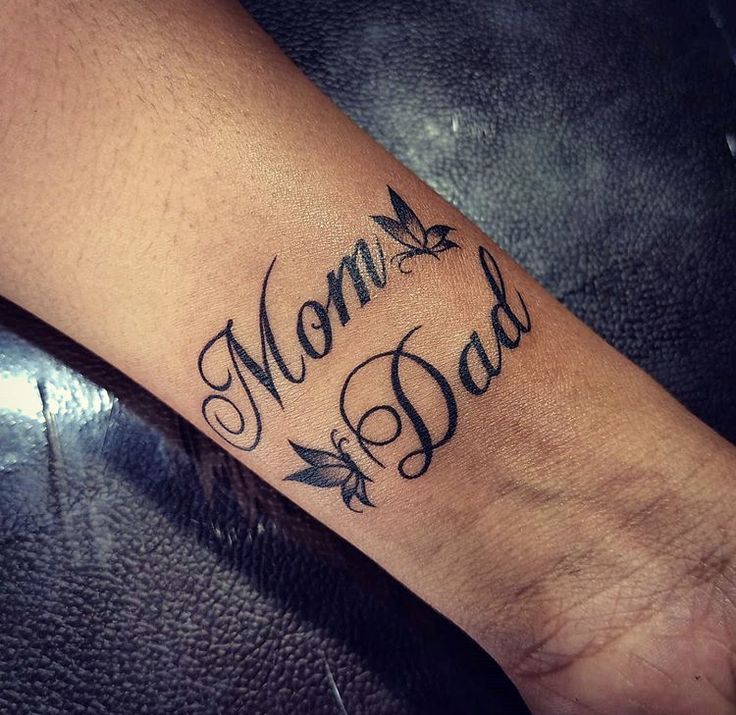 Hình xăm chữ "Mom Dad" trên cổ tay, phong cách chữ nghệ thuật, chi tiết rõ nét, độ phân giải HD.