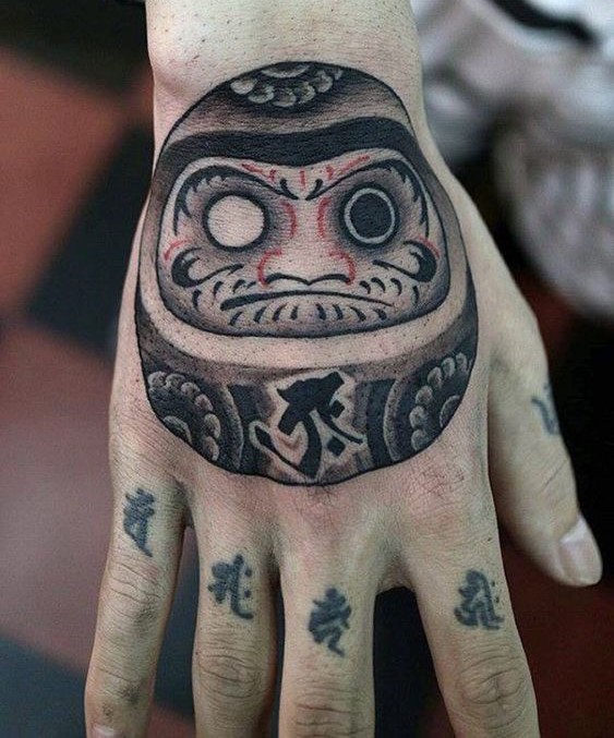 Hình xăm Daruma một bên mắt trên mu bàn tay nổi bật Hình xăm Daruma phong cách blackwork trên mu bàn tay, chi tiết sắc nét, độ phân giải HD.