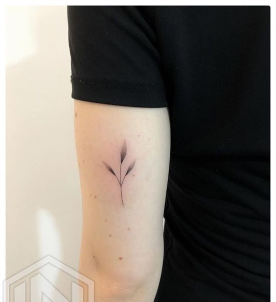 Hình xăm lá mini trên cánh tay, phong cách blackwork, chi tiết tinh tế, ảnh HD.