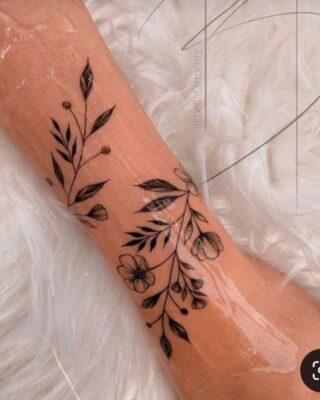 Hình xăm hoa lá đen, phong cách blackwork, vị trí cánh tay, chi tiết, độ phân giải HD.
