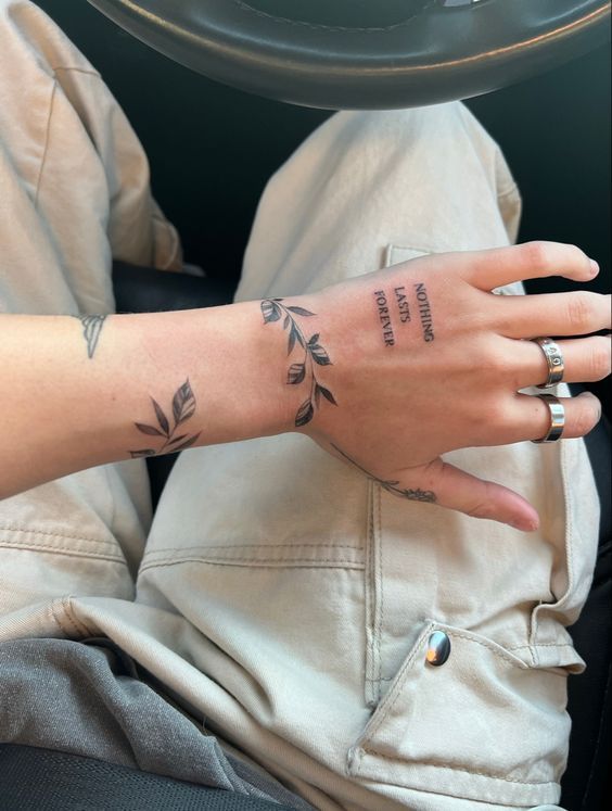 Hình xăm lá trên cổ tay phong cách blackwork, chữ trên ngón tay. Ảnh chi tiết cao, độ phân giải HD.