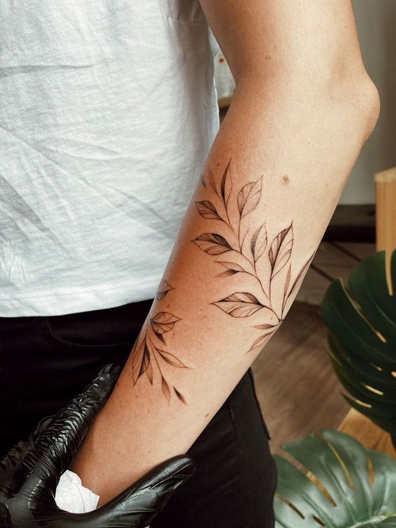 Hình xăm lá cây trên cánh tay, phong cách blackwork, chi tiết sắc nét, ảnh HD.