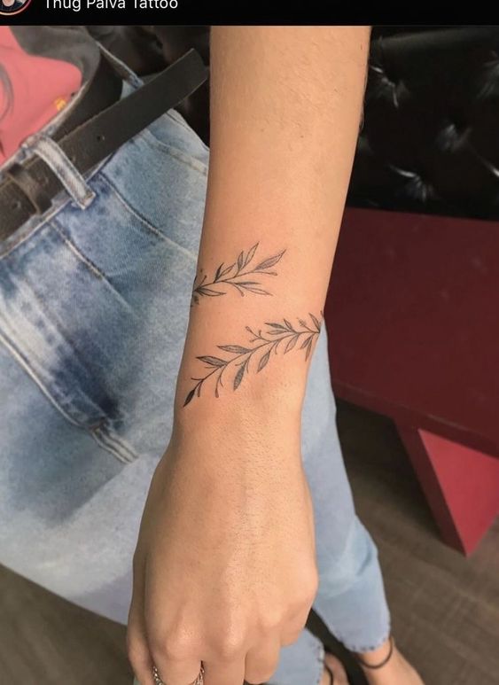 Hình xăm nhánh lá trên cổ tay, phong cách blackwork, chi tiết tinh tế, độ phân giải HD.