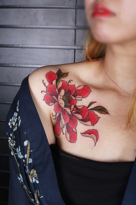 Xăm hoa quỳnh gần xương quai xanh Hình xăm hoa màu đỏ trên vai, phong cách cổ điển, chi tiết rõ nét, ảnh chất lượng HD.