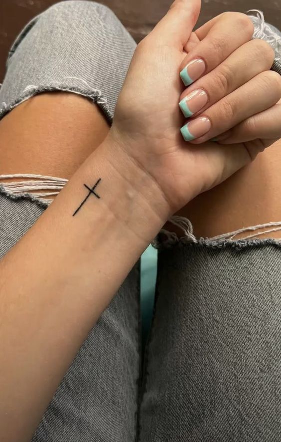 Hình xăm chữ thập nhỏ trên cổ tay, phong cách blackwork, chi tiết đơn giản, độ phân giải HD.