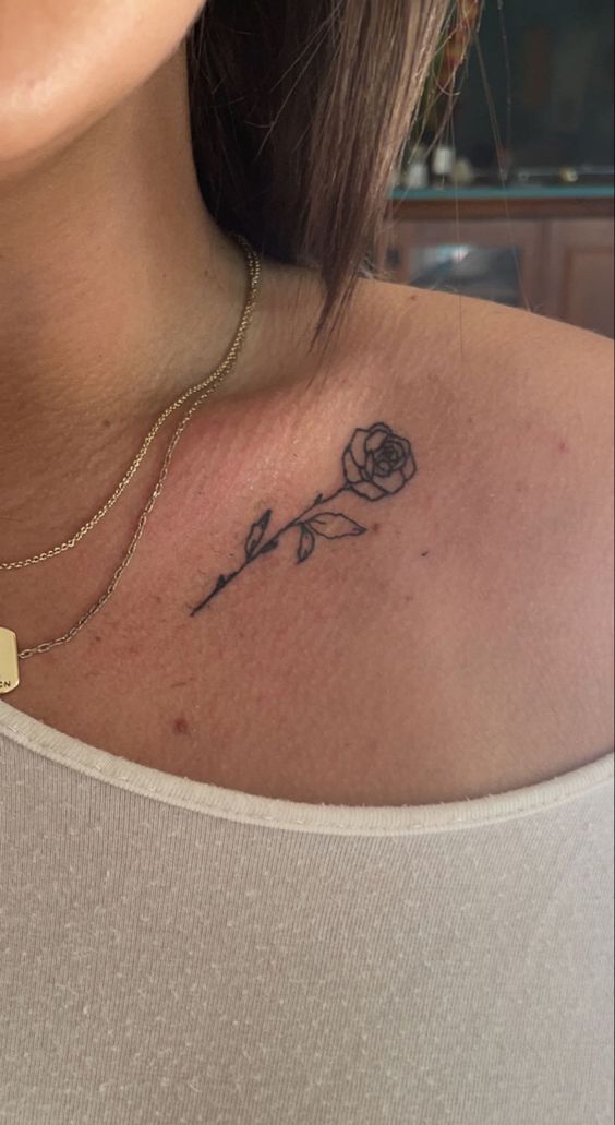 Hình xăm hoa hồng mini trên vai, phong cách blackwork, chi tiết rõ nét, độ phân giải HD.