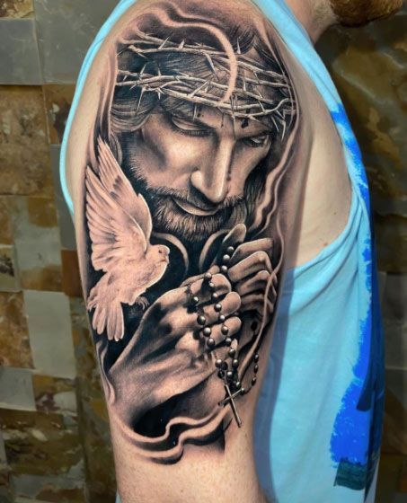 Hình xăm tôn giáo trên bắp tay, phong cách blackwork, chi tiết cao, độ phân giải HD.