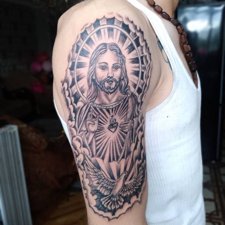 Hình xăm tôn giáo trên bắp tay, phong cách blackwork, chi tiết cao, độ phân giải HD.