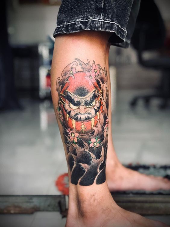 Ý tưởng xăm khác biệt với hình Daruma một mắt cực chất Hình xăm Daruma màu sắc trên chân, phong cách truyền thống Nhật Bản, chi tiết cao, ảnh HD.