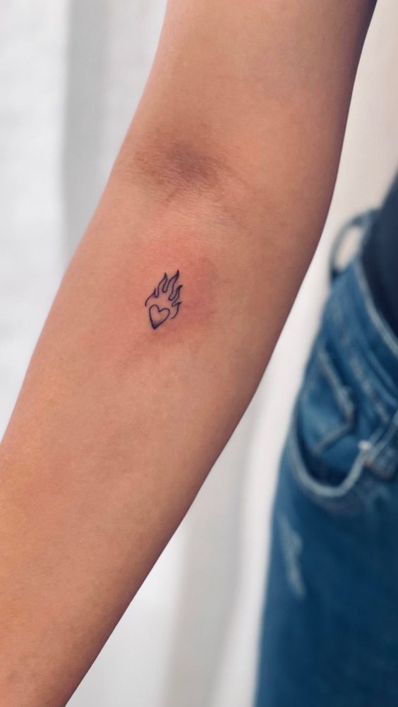 ý tưởng xăm lửa nhỏ gọn cho chị em Hình xăm mini trái tim và ngọn lửa trên cánh tay, phong cách blackwork, ảnh HD.