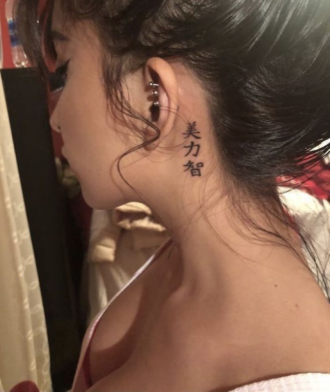 Hình xăm chữ cổ điển sau tai, phong cách blackwork, độ phân giải HD.