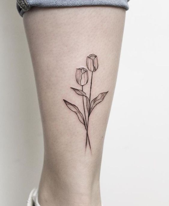 Hình xăm hoa tulip đường nét đơn giản trên chân, phong cách blackwork, chi tiết rõ nét, ảnh HD.